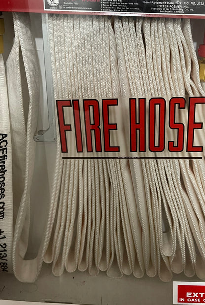 A packaged fire hose with white labeling showing the text 'FIRE HOSE'.