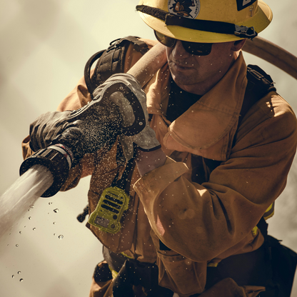 Firefighter in action, holding a hose with a neutral background
